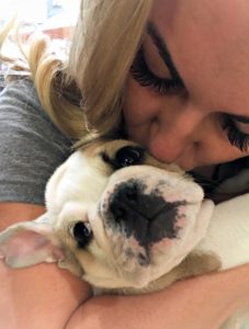 A mom kissing a puppy.